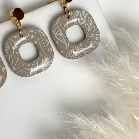 Willow earrings: handmade polymer clay squares in ash brown, with delicate white leaves dancing across the surface, gold plated posts, capturing the gentle movement of a soft breeze.